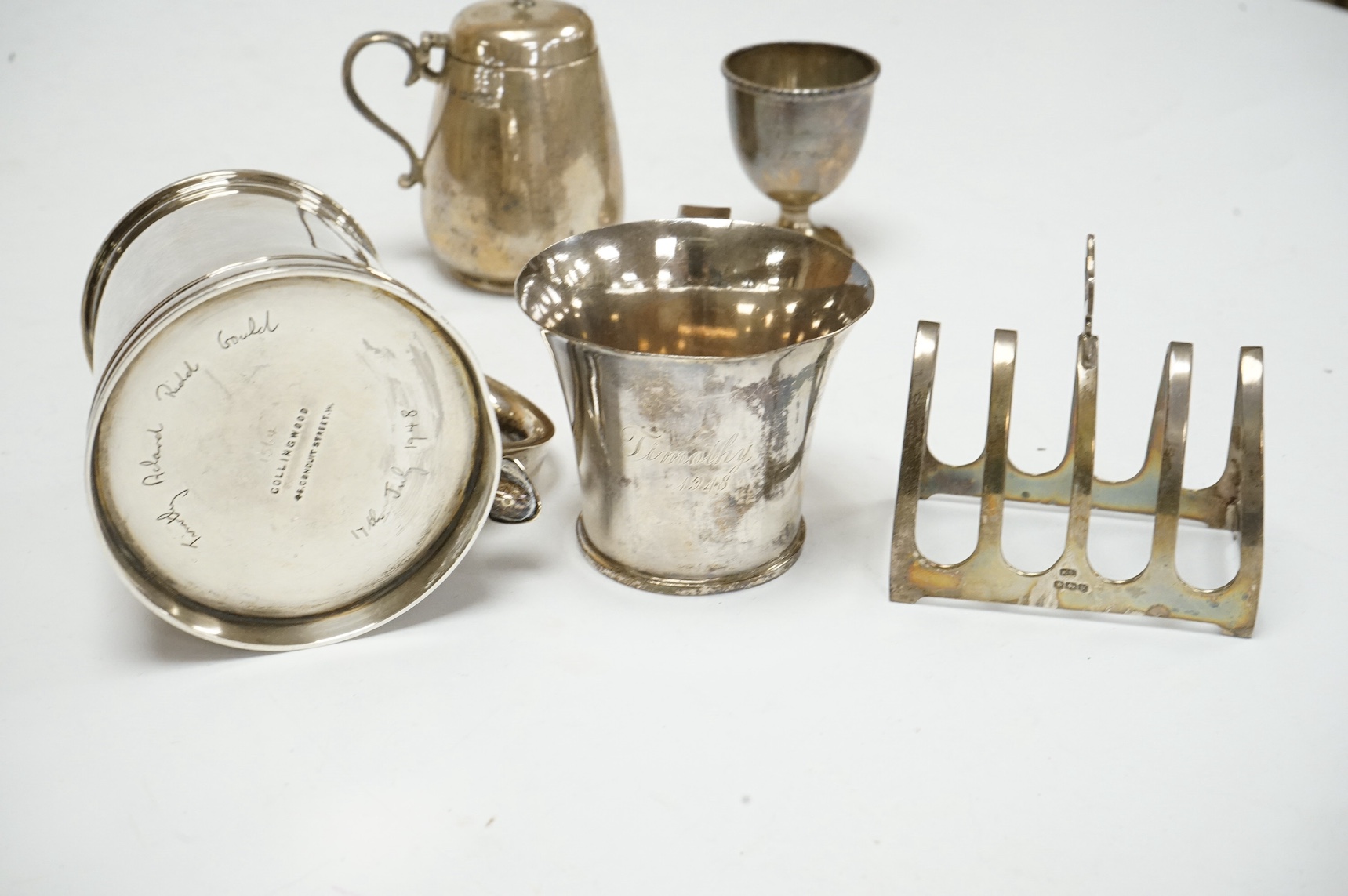 Small silver including a mug, Collingwood & Co, London, 1946, 87mm, a late Victorian mustard pot, toast rack, egg cup and an 830 standard white metal mug, 18oz. Condition - fair.